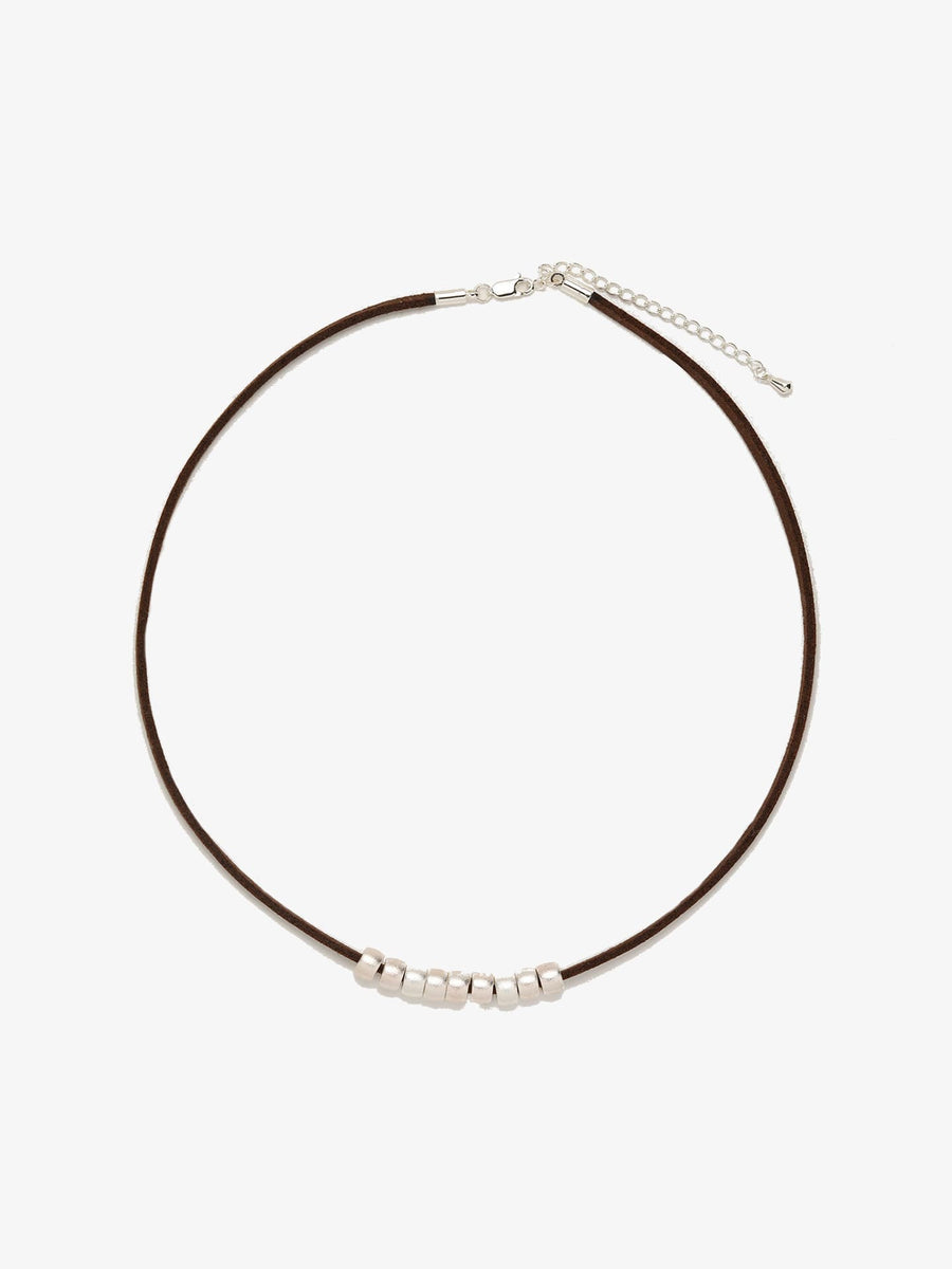 Fairyokai Balance Glide necklace with brown leather cord and textured silver bead on white background.