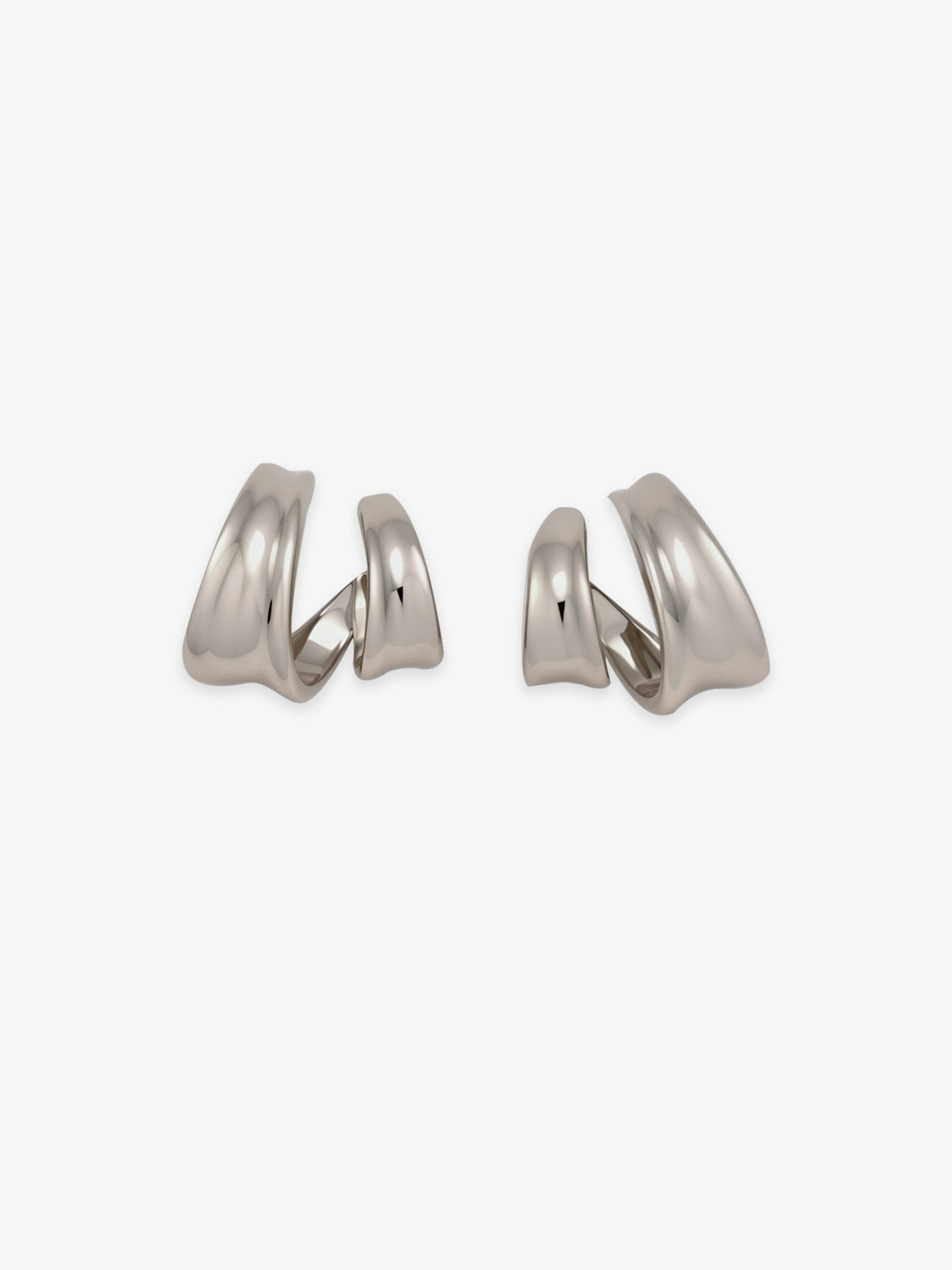 Pair of Fairyokai Double Arc sculptural open C-shape hoop earrings with white gold tone plating on white background.