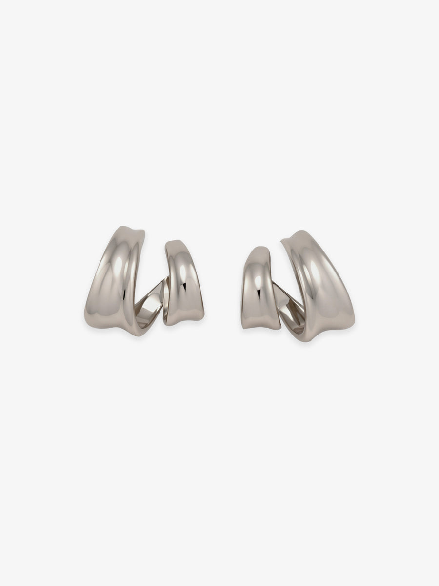 Pair of Fairyokai Double Arc sculptural open C-shape hoop earrings with white gold tone plating on white background.