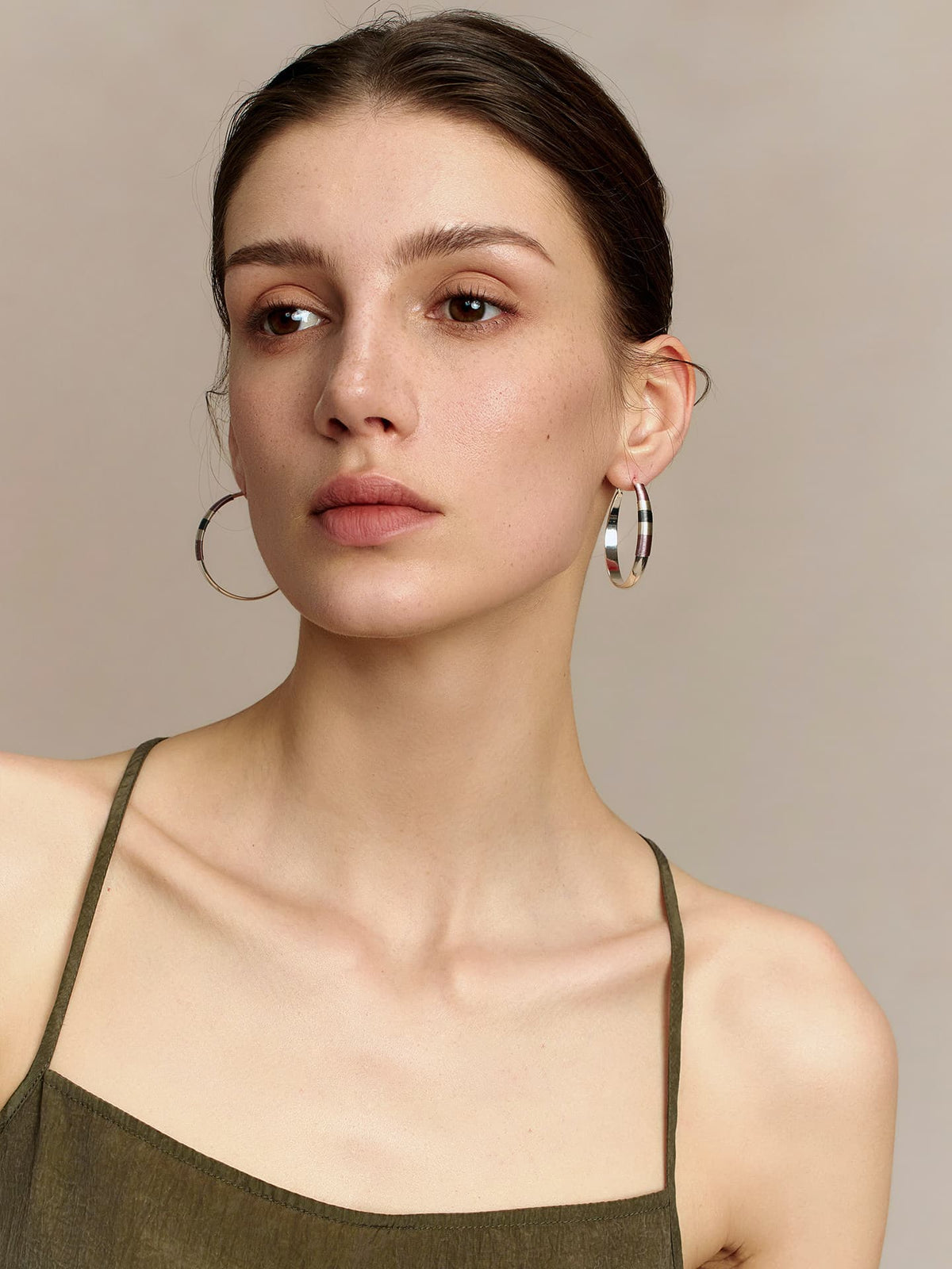 Model in a deep green thin-strap dress wearing Fairyokai Three-Color Thread hoop earrings, facing slightly to the right, side view, against a neutral background